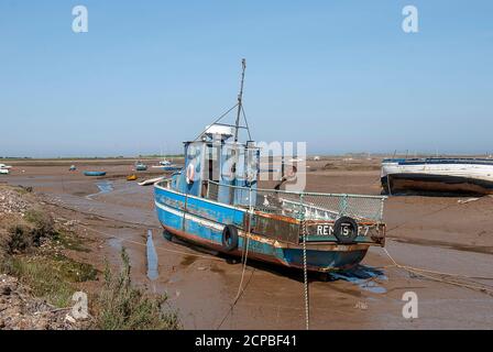 De petits bateaux se sont retrouvés à marée basse sur la côte de Norfolk, au Royaume-Uni Banque D'Images