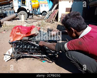 DISTRICT KATNI, INDE - 14 DÉCEMBRE 2019 : un village indien mécanicien répare un moteur de camion dans un atelier automobile ouvert. Banque D'Images