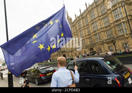 Homme marchant avec le drapeau de l'UE devant les chambres du Parlement après que la Grande-Bretagne ait voté pour quitter l'Union européenne, dans le cadre d'un référendum d'hier, les chambres du Parlement, Westminster, Londres, Royaume-Uni. 24 juin 2016 Banque D'Images
