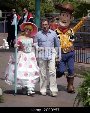 Actor Tim Allen (C) is escorted by by Disney and Pixar characters from the film 'Toy Story' Little Bo Peep and Woody (R) as they take part in the official opening of the new attraction 'Buzz Lightyear Astro Blasters' in Tomorrowland at the Disneyland theme park as the celebration of Disneyland's 50th anniversary 'The Happiest Homecoming on Earth' begins in Anaheim, California, May 4, 2005. Allen was the voice talent for Buzz Lightyear in the film. Walt Disney, founder of the Walt Disney Company and visionary behind the creation of Disneyland, opened the park on July 17, 1955. REUTERS/Fred Prou