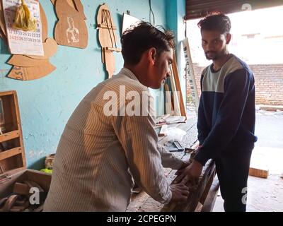 DISTRICT KATNI, INDE - 08 JANVIER 2020 : deux travailleurs du bois indiens travaillent ensemble à l'atelier. Banque D'Images