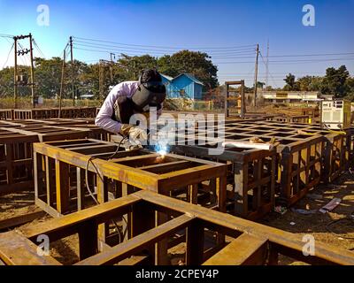 DISTRICT KATNI, INDE - le 17 JANVIER 2020 : un ouvrier d'entretien asiatique soulage des filets de fer pendant les travaux de construction de ponts de chemin de fer. Banque D'Images