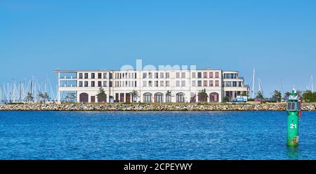 Cet immeuble moderne se trouve sur la jetée en pierre de la mer Baltique, à côté du port et des bateaux à voile. Banque D'Images