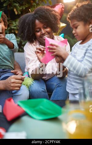 Mère avec enfants s'amuser avec des voiliers en papier colorés Banque D'Images