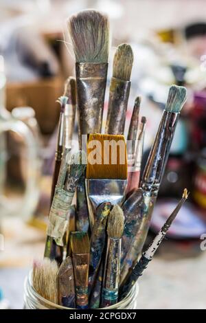 Pinceaux de l'artiste dans un pot pris dans le studio de l'artiste. Banque D'Images