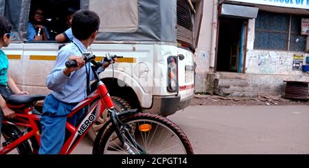 DISTRICT KATNI, INDE - 15 AOÛT 2019 : un garçon d'école indien à vélo après les vacances. Banque D'Images