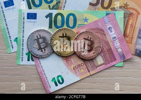 Image symbole monnaie numérique, pièce physique Bitcoin, argent, or, bronze, sur les billets en euros Banque D'Images