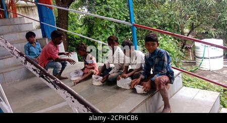 DISTRICT KATNI, INDE - 10 OCTOBRE 2019: Village indien les enfants pauvres s'assoir dans une rangée pour mendier de l'argent au temple religieux hindou. Banque D'Images