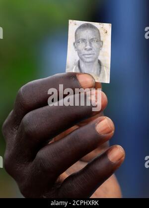 Qui Ment Qui A Tué Simon Simon Wani, réfugié du Sud-Soudan, montre la photo de son fils qui a