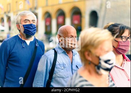 Foule de personnes adultes marchant dans la rue de la ville avec le visage Masque activé - Nouveau concept de style de vie normal - Focus sur homme bald avec masque de protection marron Banque D'Images
