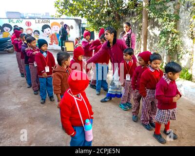 DISTRICT KATNI, INDE - 13 JANVIER 2020 : les enfants des écoles du village indien se tenant ensemble dans la cour à aire ouverte. Banque D'Images