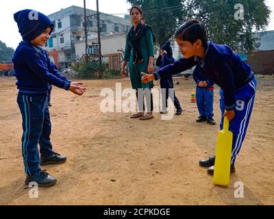 DISTRICT KATNI, INDE - 17 JANVIER 2020: Enfants indiens d'âge préscolaire jouant ensemble au terrain de sol sur terrain de sport. Banque D'Images