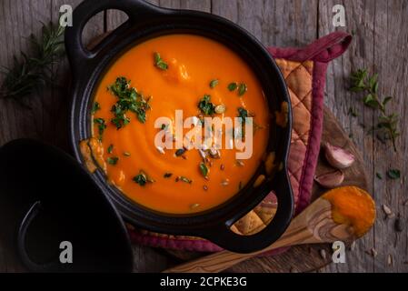 Soupe de potiron chaude dans une casserole sur fond sombre Banque D'Images