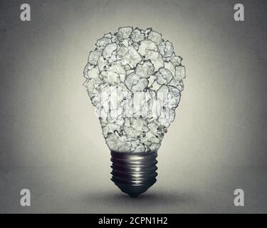 Ampoule en papier froissé isolée sur fond de mur gris. Concept d'éducation à la solution de stratégie de créativité Banque D'Images