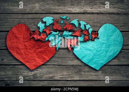 Concept de relation romantique comme deux coeurs en morceaux déchirés papier sur bois abîmé comme symbole pour l'attachement romance et échange de sentiments et Banque D'Images