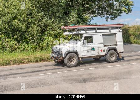 White Land Rover est utilisé comme véhicule utilitaire pour Western Power distribution sur une route rurale de Cornwall. WPD est le principal fournisseur d'électricité de Cornish Banque D'Images