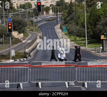 Jérusalem, Israël. 19 septembre 2020. Les Juifs ultra-orthodoxes marchent derrière un barrage routier à Jérusalem, lors d'un verrouillage du coronavirus sur Rosh Hashanah, le nouvel an juif, le samedi 19 septembre 2020. Israël est entré dans une période de confinement à l'échelle nationale de trois semaines avant le début de Rosh Hashanah dans la tentative du gouvernement de réduire la propagation rampante de COVID-19, obligeant les résidents à rester à la maison pendant les hautes vacances juives. Photo par Debbie Hill/UPI crédit: UPI/Alay Live News Banque D'Images