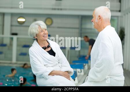 Senior couple relaxing by swimming pool Banque D'Images