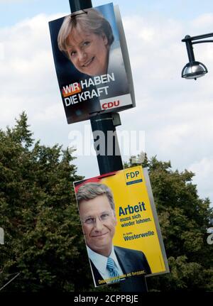 Election posters of the conservative Christian Democratic Union (CDU) party showing German Chancellor Angela Merkel (top) and of the liberal FDP party showing its leader Guido Westerwelle are seen in central Berlin August 18, 2009. Germany will vote in a general election September 27.  REUTERS/Thomas Peter  (GERMANY POLITICS ELECTIONS)