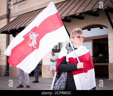 Varsovie, PL. 19 septembre 2020. Une femme est vue à Varsovie, en Pologne, portant le drapeau biélorusse blanc-rouge-blanc avec le symbole Pogon le 19 septembre 2020. Plusieurs dizaines de personnes, principalement des Biélorusses, ont participé à une marche dans le centre de Varsovie pour célébrer la première utilisation du drapeau blanc-rouge-blanc, le 19 septembre 1991, drapeau alternatif qui est aujourd’hui un symbole de l’opposition biélorusse. Credit: SIPA USA/Alay Live News Banque D'Images