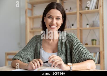 Portrait en tête souriant femme d'affaires parlant, regardant l'appareil photo Banque D'Images