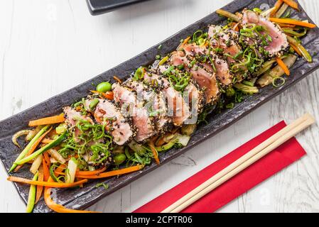 Cuisine japonaise. Tatataki de thon. Thon poêlé aux graines de sésame et sauce soja, wasabi, lime. Banque D'Images