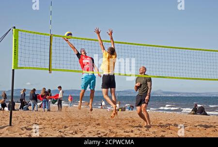 Météo au Royaume-Uni : plage de Portobello, Édimbourg, Écosse. 19 septembre 2020. Cet après-midi, le bord de mer attire encore des foules pour profiter du temps ensoleillé, bien que le vent frais donne l'impression de la température de 14 degrés par rapport à la température réelle de 16 degrés. Photo : une équipe de volley-ball de groupe communautaire est heureuse de revenir à l'activité. Banque D'Images