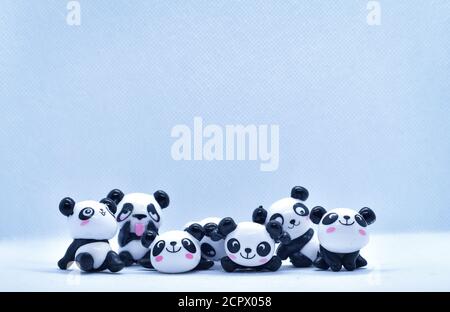 Petites figurines en porcelaine panda isolées sur fond noir Banque D'Images