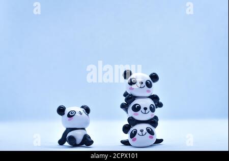 Petites figurines en porcelaine panda isolées sur fond noir Banque D'Images