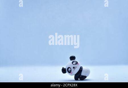 Petite figurine en porcelaine panda isolée sur fond noir Banque D'Images