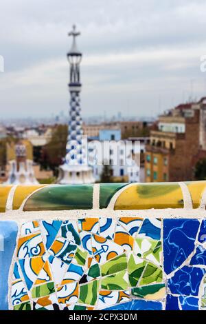 Barcelone, parc Güell, banc décoré de céramiques cassées, dans la tour d'arrière-plan du pavillon du porteur Banque D'Images