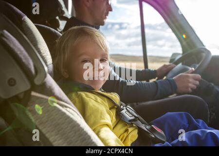 Mignon petit garçon, enfant assis sur le siège avant dans le siège d'enfant sur grand van de camping, souriant heureux Banque D'Images