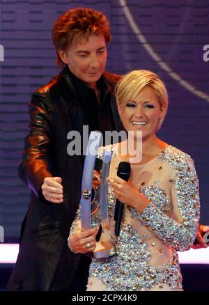 Helene Fischer receives the trophy for German Language Schlager from singer Barry Manilow (L) at the Echo Music Awards ceremony Berlin March 22, 2012. Established in 1992, the German Phonographic Academy honours national and international artists with the Echo German music prize.  REUTERS/Fabrizio Bensch (GERMANY  - Tags: ENTERTAINMENT)  (ECHO SHOW)