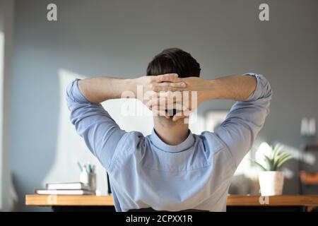 Vue arrière de l'homme détendez-vous au bureau à domicile Banque D'Images