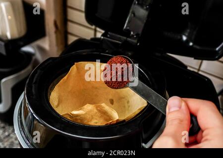 Filtrez le café sur la cuillère pour le verser dans la machine le matin Banque D'Images