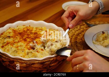 Chou-fleur avec sauce au béchamel et fromage fondu sur le dessus plat en céramique avec couvercle de tapis de paille Banque D'Images