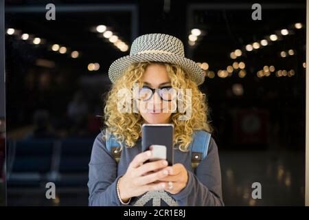 portrait et gros plan d'une belle femme blonde et maurie regardant l'appareil photo souriant - des gens heureux voyageant à l'aéroport - des vacances à l'extérieur Banque D'Images