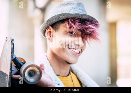 Portrait de beau gai jeune homme teeanger garçon sourire et regardez la caméra - les gens modernes avec un autre look et les cheveux colorés - Banque D'Images