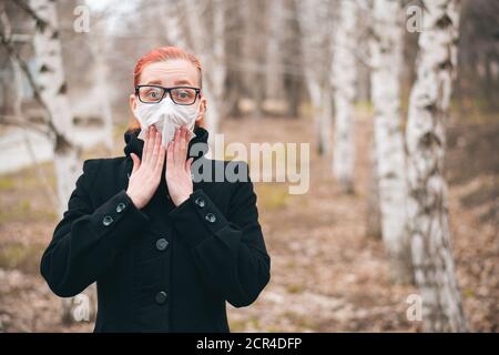 Fille effrayée par la nouvelle de propagation du virus. Femme dans la rue pendant l'épidémie de coronavirus. Concept de panique et de peur avec espace de copie. Banque D'Images