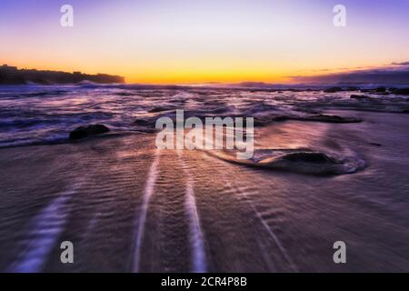 Lever de soleil orange foncé sur la plage Bronte, dans la banlieue est de Sydney, sur l'océan Pacifique. Banque D'Images