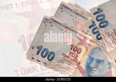 100 les billets de liras turcs sont empilés sur le fond d'un grand billet de banque semi-transparent. Présentation abstraite de la monnaie nationale. Concept d'entreprise Banque D'Images