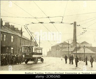 . Journal de chemin de fer électrique . les illustrations montrent une des voitures Bradford passant des camions qui, avec la voiture, occupent la largeur de la rue. À Leeds, les trolleybus sans piste circulent sur une distance de près d'un mile dans une rue où un tramway électrique est déjà en service. Afin d'éviter l'utilisation de. 156 JOURNAL DE CHEMIN DE FER ÉLECTRIQUE. [Vol XXXVIII, N° 4. Deux jeux de fils aériens les wagons de chariot sans piste se servent du fil positif du système de tramway et ils sont également équipés d'un collecteur qui fonctionne sur le rail de tramway et effectue la connexion négative. Ce collectorisme Banque D'Images