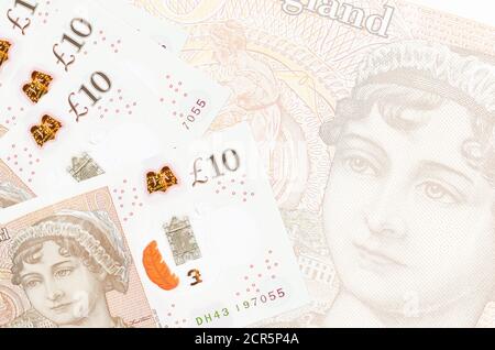 Les billets de 10 livres sterling sont empilés sur le fond d'un grand billet de banque semi-transparent. Arrière-plan commercial abstrait avec espace de copie Banque D'Images