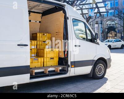 Hambourg, Allemagne - 20 mars 2020 : minibus de livraison de colis Mercedes-Benz Sprinter blanc avec boîtes jaunes avec lettres et cartons de Deutsche Post DHL - centre-ville de Hambourg Banque D'Images