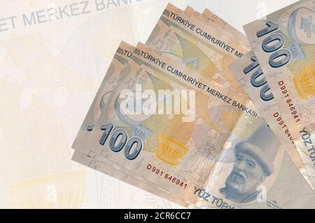 100 les billets de liras turcs sont empilés sur le fond d'un grand billet de banque semi-transparent. Présentation abstraite de la monnaie nationale. Concept d'entreprise Banque D'Images
