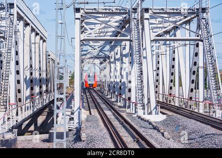 Le train à grande vitesse traverse le pont en approchant de la plate-forme de la gare. Banque D'Images