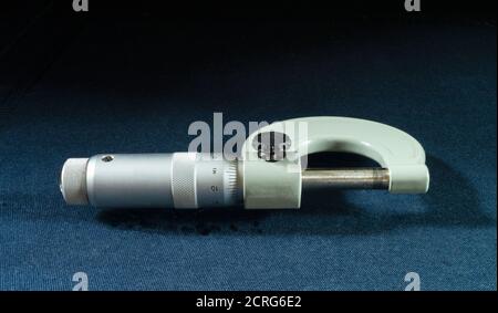 Le micromètre de l'instrument activé fait passer la table en bleu sur le noir Background.instrument mécanique pour la mesure à partir d'aciers Banque D'Images