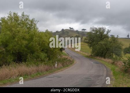 Campagne vallonnée et route près de Lostock dans la région Upper Hunter en Nouvelle-Galles du Sud, Australie. Banque D'Images