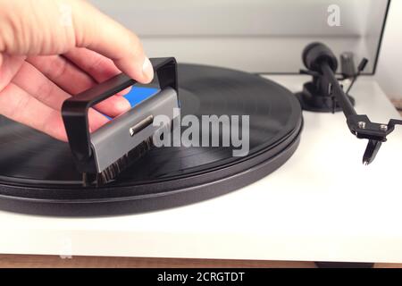 Nettoyage des mains de l'homme vinyle avec brosse spéciale - platine vinyle lecteur de disques, vintage lecteur de disques. Tendances du concept de musique. Technologies audio pour Banque D'Images