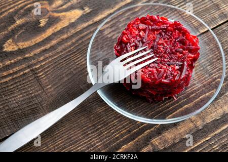 salade végétarienne de betteraves, carottes, ail et huile d'olive sur une assiette est sur la table, il ya une fourchette à proximité Banque D'Images